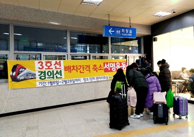 8일 경기 고양시 일산의 한 아파트 단지 앞에서 입주민들이 지하철3호선과 경의선 증차를 요구하는 서명운동을 벌이고 있다. 일산연합회 제공