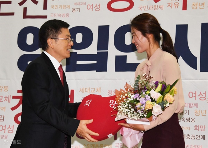 체육계 미투 1호인 김은희씨에게 황교안 대표가 환영의 꽃다발과 ‘희망’ 글자가 새겨진 쿠션을 전달하고 있다. 오대근기자