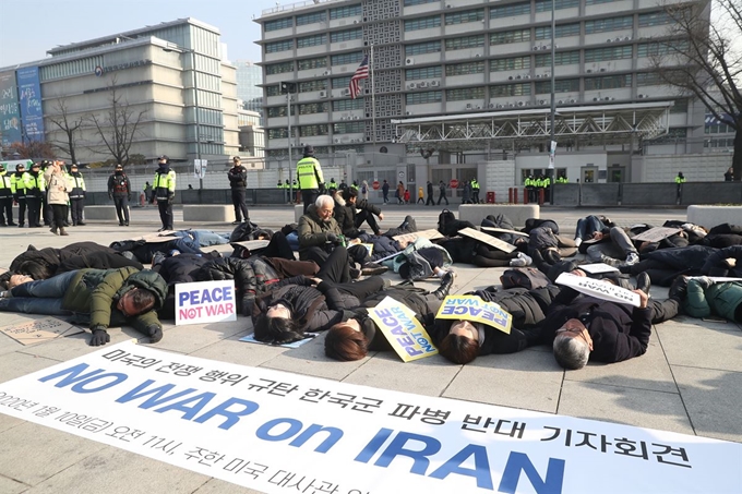 10일 종로구 주한미국대사관 앞에서 시민단체 회원들이 미국의 전쟁 행위를 규탄하고 한국군 파병을 반대하는 기자회견을 한 뒤 쓰러진 사람들의 모습을 표현하는 퍼포먼스를 하고 있다. 연합뉴스