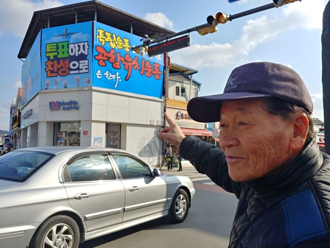 의성주민 김모씨가 13일 의성군청 맞은편 건물에 설치된 공항유치 홍보 현수막을 가리키고 있다. 권성우기자 ksw1617@hankookilbo.com