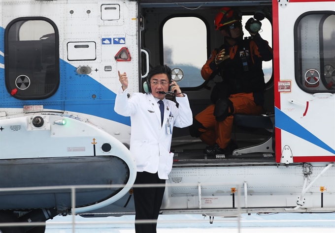 지난해 9월 6일 경기 수원시 아주대학교병원 경기남부권역외상센터에서 열린 '일곱 번째 닥터헬기 출범식'에서 이국종 센터장이 헤드셋을 착용하고 관계자와 이야기를 나누고 있다. 연합뉴스