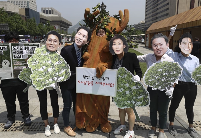 지난해 6월 서울 광화문광장에서 열린 ‘도시공원일몰제 대응 국회 긴급 입법 촉구 및 시민행동 선포 기자회견’에서 환경운동연합 회원들이 각 정당 원내대표들 얼굴 모양의 마스크를 착용한 채 도시공원 지키기를 약속하는 내용의 퍼포먼스를 하고 있다. 연합뉴스