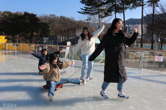 학생들이 15일 대구 수성구 수성못 상화동산 동편 얼음썰매장에서 얼음썰매 대결을 펼치고 있다. 얼음썰매장은 내달 9일까지 매일 오전10시부터 오후7시40분까지 운영된다. 입장료 1,000원으로 얼음썰매 뿐 아니라 눈슬로프와 집라인까지 이용할 수 있다. 윤희정 기자 yooni@hankookilbo.com