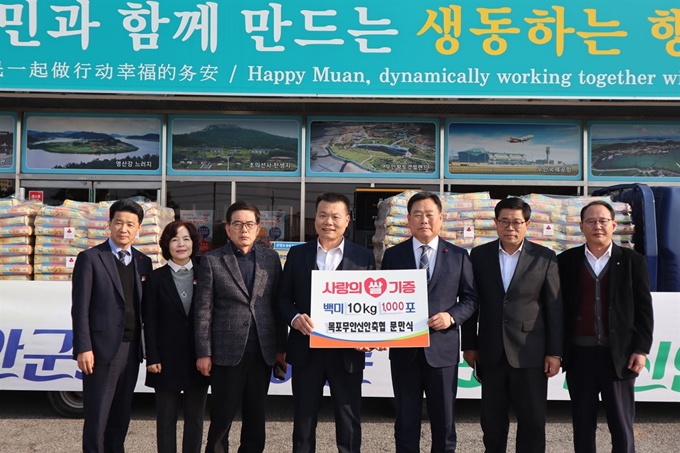 14일 무언군청에서 문만식(가운데) 목포무안신안축협조합장이 김산 무안군수에게 사랑의쌀 1000포대와 승달장학금을 1000만원을 기탁했다. 축협 제공