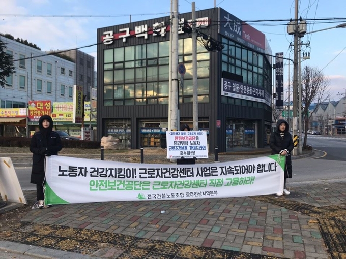 광주근로자건강센터 직원들이 고용 승계를 요구하는 피켓시위를 하고 있다. 광주근로자건강센터 제공.