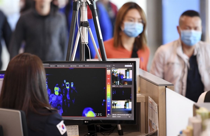 중국 우한에서 집단 발생한 폐렴과 관련해 9일 인천국제공항 제1여객터미널에서 중국발 항공기 입국자들이 열감지카메라가 설치된 검색대를 통과하고 있다. 뉴시스