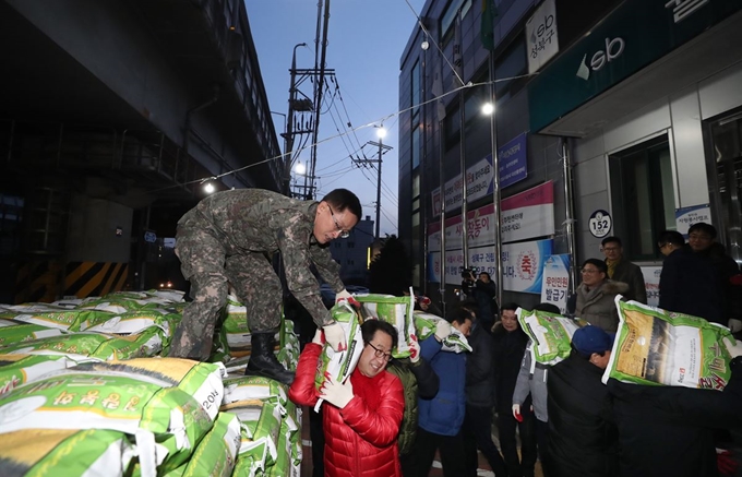 16일 서울 성북구 월곡2동 주민센터에서 직원들이 '얼굴없는 천사'로부터 배달된 쌀 300포를 옮기고 있다. 월곡2동 주민센터는 2011년부터 10년째 이름을 알리지 않고 쌀을 기부해온 한 시민의 뜻을 기리기 위해 이날 10주년 기념행사를 실시했다. 연합뉴스