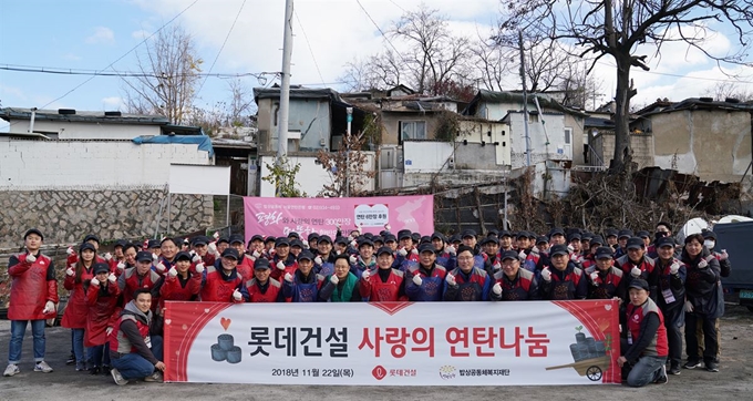 롯데건설 임직원들이 사랑의 연탄나눔 봉사 활동을 한 뒤 기념촬영 하고 있다. 롯데건설 제공