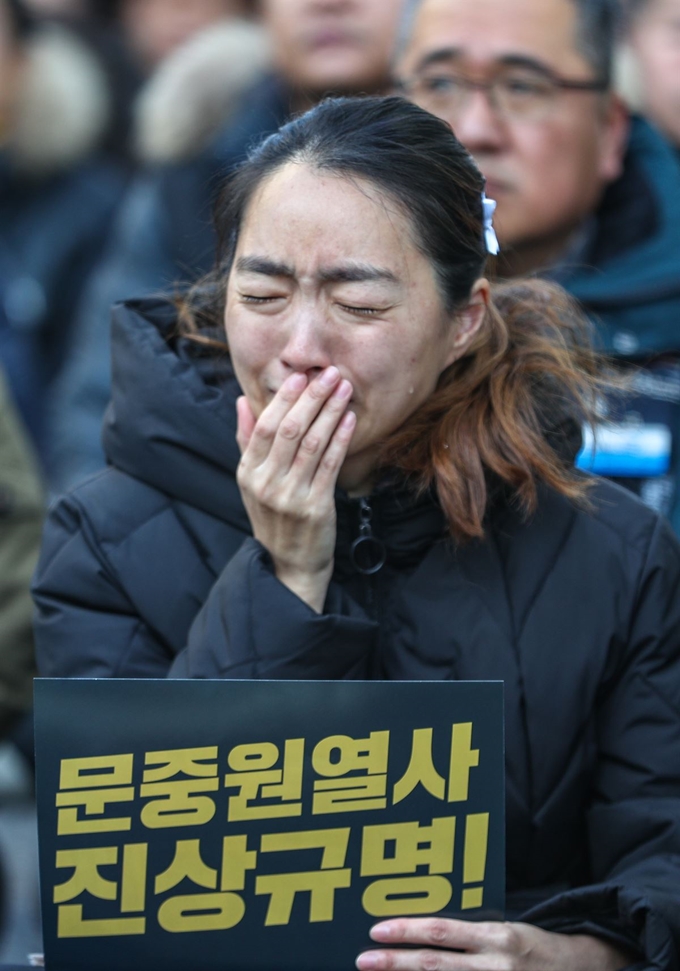 18일 오후 서울 종로구 종로타워 앞에서 열린 '고 문중원 열사 진상규명 촉구 민주노총 결의대회'에서 고 문중원 기수의 부인 오은주 씨가 눈물을 흘리고 있다.이번 결의대회에서 고 문중원 기수 유족과 민주노총은 "마사회 소속 7명의 기수, 조교사를 죽음으로 몰고 간 부정과 비리의 경마를 멈춰라"고 밝혔다. 뉴스1