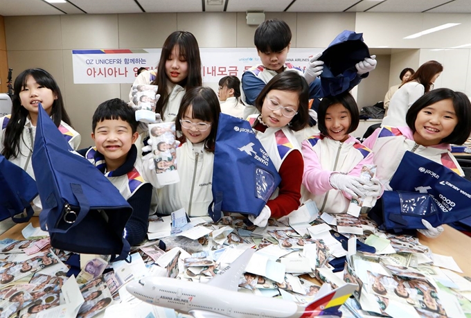 지난 17일 서울 오쇠동 아시아나항공 교육훈련동에서 겨울방학을 맞이한 임직원 자녀들이 '사랑의 기내 동전 모으기 캠페인'으로 모인 동전의 계수 봉사활동에 참여하고 있다. 아시아나항공 제공