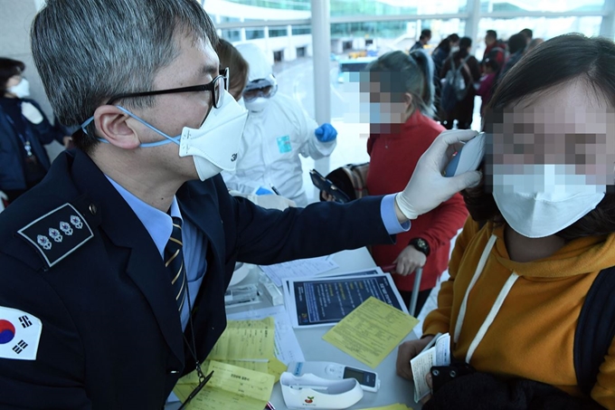 중국 '우한 폐렴' 확진환자가 국내에서 처음으로 발생한 20일, 질병관리본부 국립검역소 직원들이 인천국제공항 제2터미널 입국장에서 우한발 비행기로 국내로 들어온 입국자 전체를 대상으로 발열 검사를 하고 있다. 영종도=서재훈기자