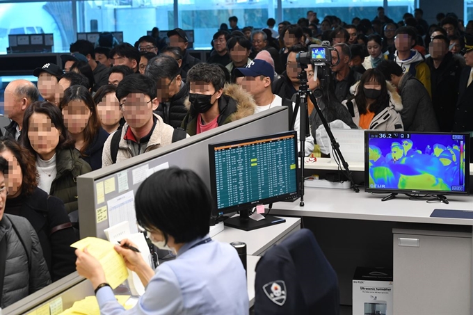 20일 오후 인천국제공항 제2터미널 입국장에서 질병관리본부 국립검역소 직원들이 동남아,우한발 비행기 입국자들을 발열 검사하고 있다. 영종도=연합뉴스