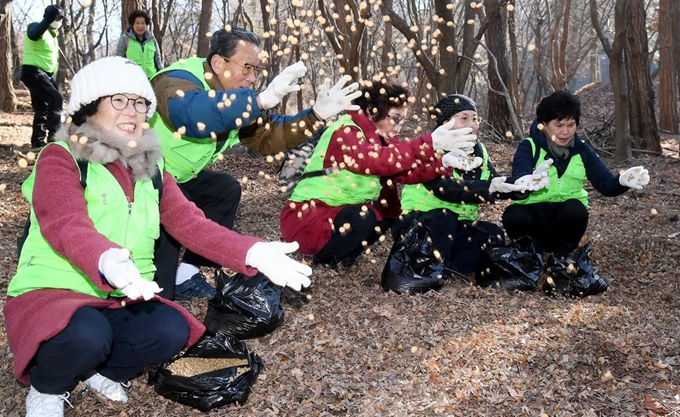 자연보호중앙연맹 대전시 중구협의회 회원들이 21일 보문산에서 야생동물을 위한 먹이를 흩뿌리고 있다. 대전 중구 제공