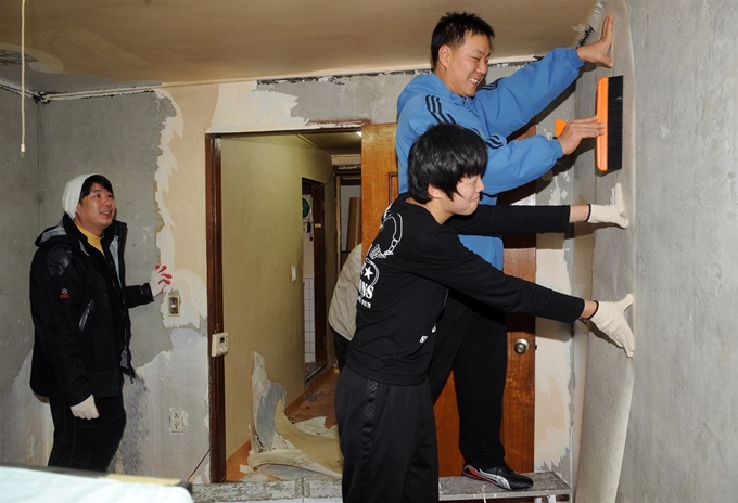 서울의 한 반지하 주택에서 벽지를 새로 바르고 있다. 한국일보 자료사진