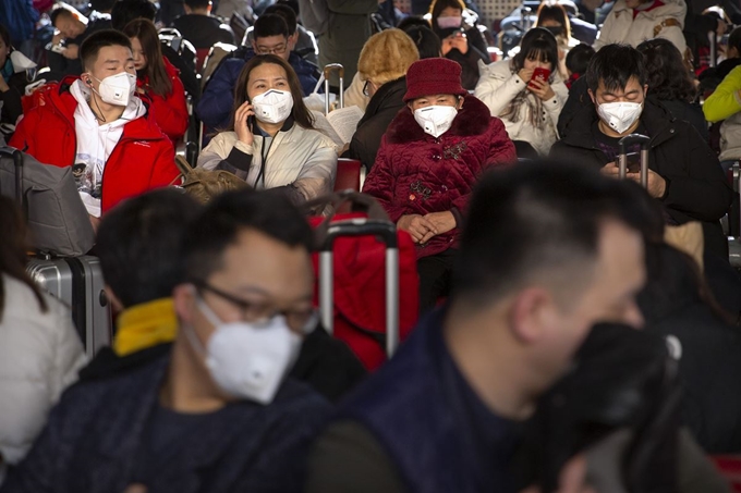 춘제연휴를 맞아 기차편으로 고향을 찾는 중국 귀성객들이 22일 저마다 마스크를 쓴 채 베이징서역에서 열차를 기다리고 있다. 베이징=AP 연합뉴스