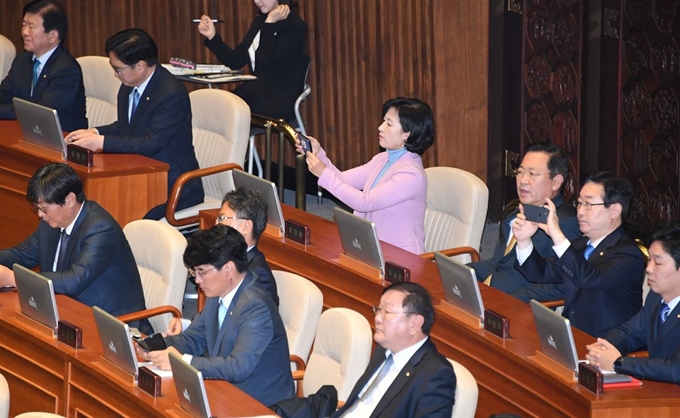 2017년 11월 국회 본회의장에서 문재인 대통령이 예산안 관련 시정 연설을 하는 동안 추미애 대표가 스마트폰으로 연설 장면을 찍고 있다. 오대근기자