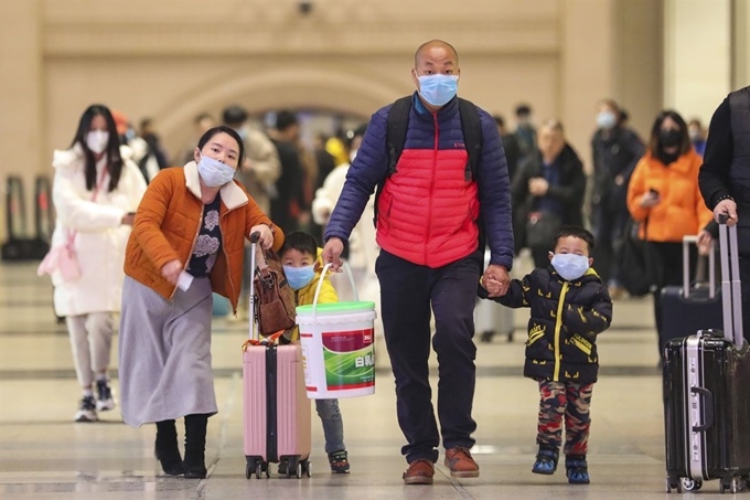 지난 21일 신종 코로나바이러스가 급속히 확산하고 있는 중국 후베이성 우한의 한커우(漢口)역에서 여행객들이 마스크를 쓴 채 이동하고 있다. 우한 AP=연합뉴스