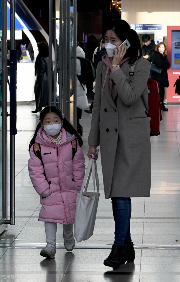 설 연휴를 하루 앞둔 23일 오전 서울역에서 한 귀성 가족이 '우한폐렴'의 영향으로 마스크를 착용한 채 고향가는 길에 오르고 있다. 왕태석 선임기자 kingwang@hankookilbo.com