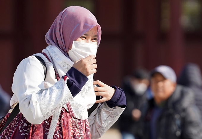 설 연휴 사흘째이자 국내에서 세 번째 우한 폐렴 확진 환자가 발생한 26일 서울 경복궁을 찾은 외국인 관광객이 마스크를 쓰고 산책을 즐기고 있다. 연합뉴스