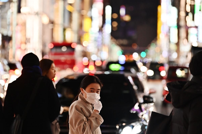 중국 우한에서 발생한 신종 코로나바이러스가 전세계적으로 급속히 확산되고 있는 가운데, 26일 중국인 여행객들이 자주 찾는 일본 도쿄 긴자거리에서 마스크를 착용한 시민이 지나가고 있다. 도쿄=AFP 연합뉴스