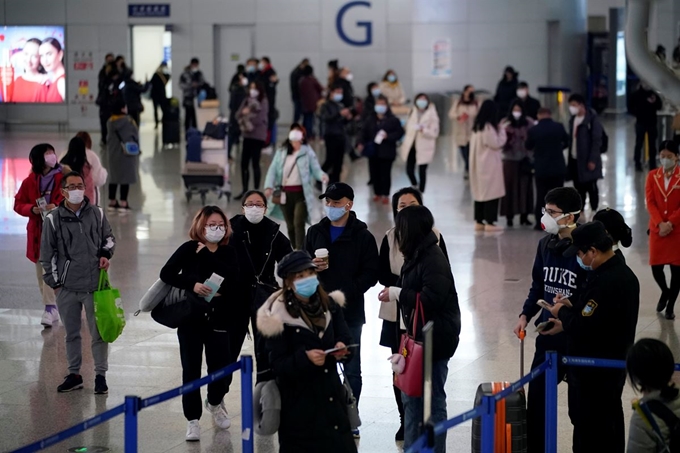 27일 중국 상하이의 푸동 국제공항에서 여행객들이 마스크를 쓰고 있는 모습. 로이터 연합뉴스