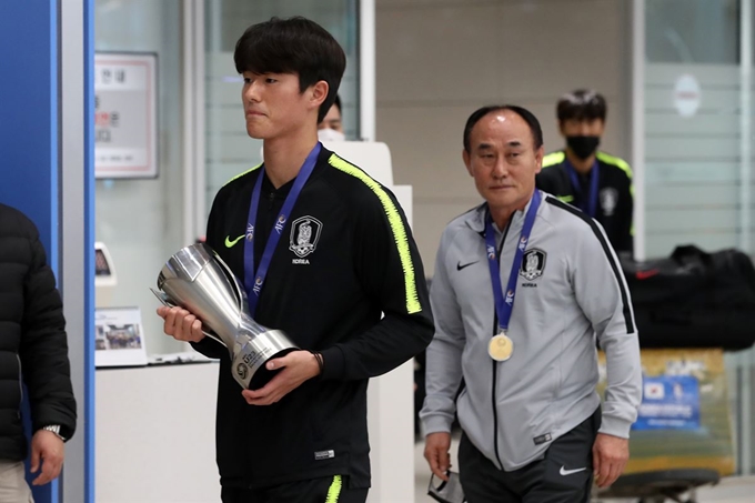 Figure 1대한민국 U-23 축구대표팀 주장 이상민이 28일 오전 인천국제공항에서 우승 트로피를 들고 기자회견장으로 이동하고 있다.대한민국 U-23 축구대표팀은 지난 26일 '2020 아시아축구연맹(AFC) U-23 챔피언십' 사우디 아라비아와의 결승전에서 1:0으로 승리로 이 대회 사상 첫 우승 및 2020 도쿄올림픽 출전권까지 따냈다. 뉴스1