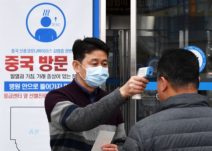 신종 코로나바이러스(우한 폐렴) 관련 정부가 어제 전염병 위기경보를 '주의'에서 '경계'로 격상한 가운데 28일 경기 덕양구 명지병원에서 병원 직원이 코로나바이러스 확산방지를 위해 출입하는 모든 사람들의 체온을 점검하고 있다. 홍인기 기자