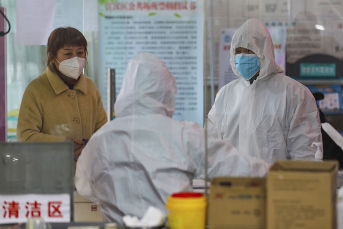 중국 우한의 한 보건소에서 27일 환자로 보이는 한 여성과 의료진이 나란히 서있다. 우한=AP 뉴시스