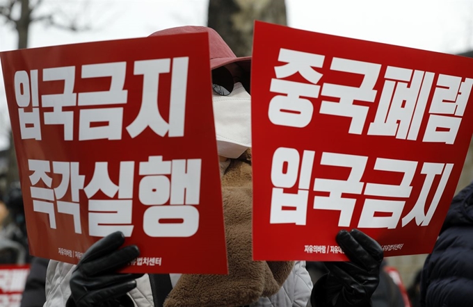 29일 오후 서울 종로구 청와대 사랑채 인근에서 열린 ‘중국인 입국금지 촉구 집회’에서 참가자들이 손팻말을 들고 있다. 뉴스1