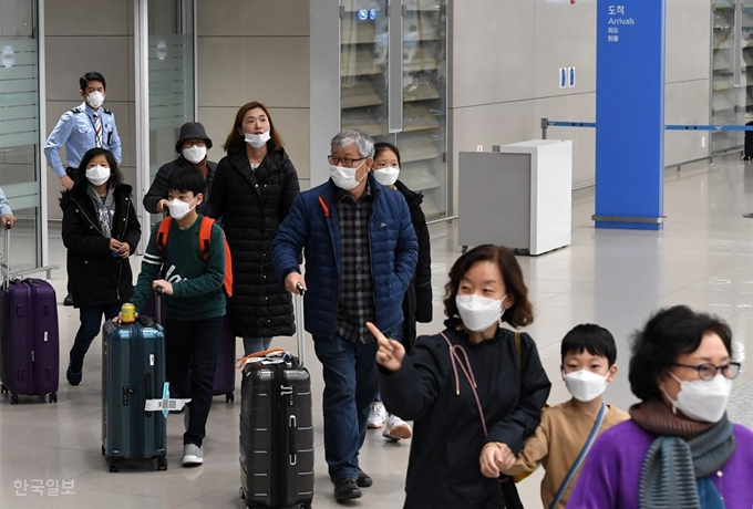 관광객, 코로나 바이러스 비상'우한 폐렴'으로 알려진 신종 코로나 바이러스 감염증에 대한 위기 경보가 '주의'에서 '경계'로 격상된 28일 인천공항을 통해 귀국하는 관광객들이 마스크를 쓴 채 입국장을 빠져나오고 있다. 서재훈 기자 spring@hankookilbo.com