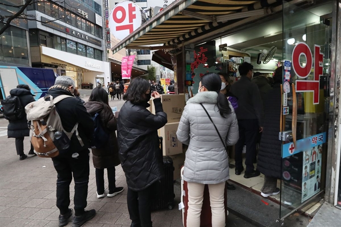 신종 코로나바이러스 감염증인 '우한 폐렴'이 세계적으로 확산하고 있는 가운데 28일 서울 중구 명동 일대의 한 약국에 외국이 관광객들이 마스크를 구입하기 위해 줄을 서 있다. 연합뉴스