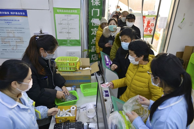 신종 코로나바이러스 감염증인 '우한 폐렴'이 확산 중인 가운데 29일 중국 장쑤성 난징의 한 약국에서 시민들이 마스크를 사기 위해 길게 줄을 서 있다. AP 연합뉴스