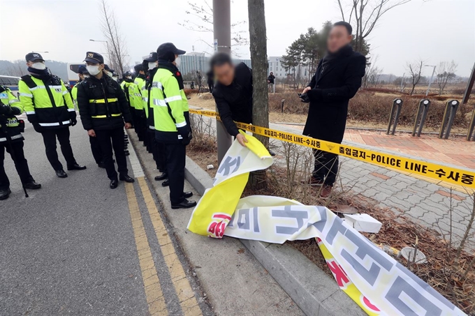 31일 오전 중국 우한 교민이 격리 수용될 충북 진천 국가공무원인재개발원 앞에서 진천 주민들이 수용 반대를 요구하는 현수막을 철거하고 있다. 진천=연합뉴스