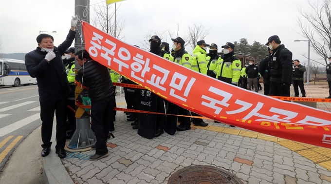 31일 오전 중국 우한 교민이 격리 수용될 충북 진천 국가공무원인재개발원 앞에서 진천 주민들이 수용 반대를 요구하는 현수막을 자진 철거하고 있다. 진천=연합뉴스