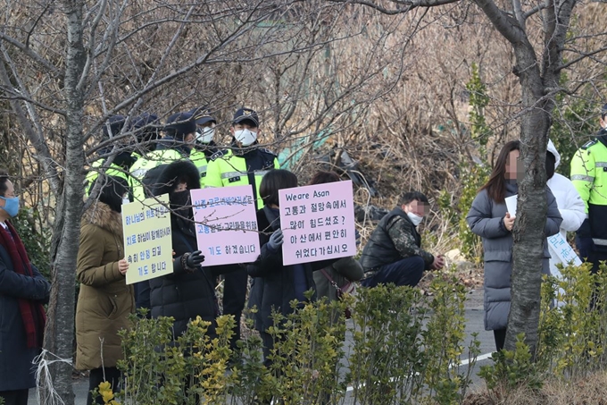 신종 코로나바이러스 감염증 발병지인 중국 후베이성 우한에서 귀국한 교민들을 태운 미니버스가 31일 임시생활시설로 지정된 충남 아산 경찰인재개발원에 도착하자 일부 주민들이 격려의 피켓을 들고 응원하고 있다. 아산=연합뉴스