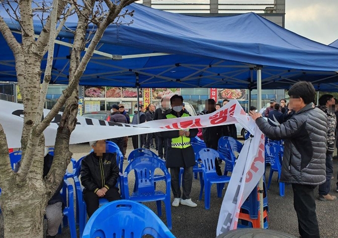 31일 중국 우한 교민이 격리 수용될 충남 아산 경찰인재개발원 앞에서 주민들이 '교민 수용 철회'를 요구하는 현수막을 철거하고 있다. 아산=연합뉴스