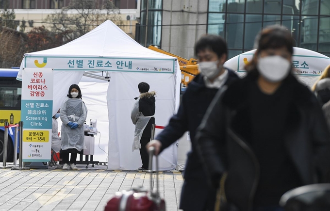 마스크를 쓴 관광객들이 31일 오후 서울 중구 명동역 인근에 신종 코로나바이러스 감염증 유입과 확산을 방지하기 위해 설치된 중구보건소 선별 진로소 앞을 지나가고 있다. 박형기 인턴기자