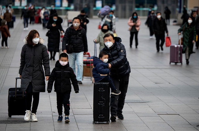 중국 베이징 고속철역에서 지난 1일 마스크를 쓴 시민들이 걸어가고 있다. 베이징=AFP 연합뉴스