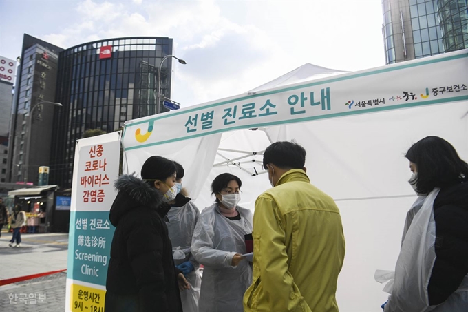 [저작권 한국일보] 중구 보건소 관계자들이 31일 오후 서울 중구 명동역 인근에 신종 코로나바이러스 감염증의 유입과 확산을 방지하기 위해 설치된 선별 진로소 앞에서 대화를 나누고 있다. 박형기 인턴기자