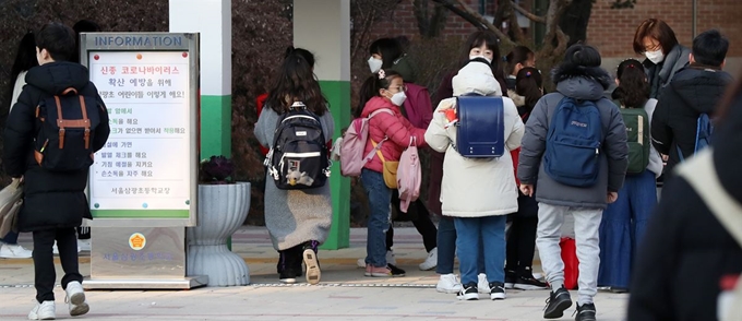 3일 오전 신종 코로나 바이러스 여파로 연기했던 개학을 다시 맞은 서울 시내 한 초등학교에서 선생님들이 등교하는 학생들의 체온 측정 및 손 소독을 지도하고 있다. 뉴스1