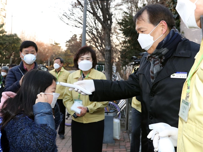 서울 강남의 봉은초등학교 한상윤 교장이 3일 오전 등교하는 학생들의 체온을 측정하고 있다. 봉은초는 신종 코로나바이러스 감염증(우한폐렴) 확산 방지를 위해 31일 예정된 개학을 연기했다가 이날 개학했다. 뉴시스