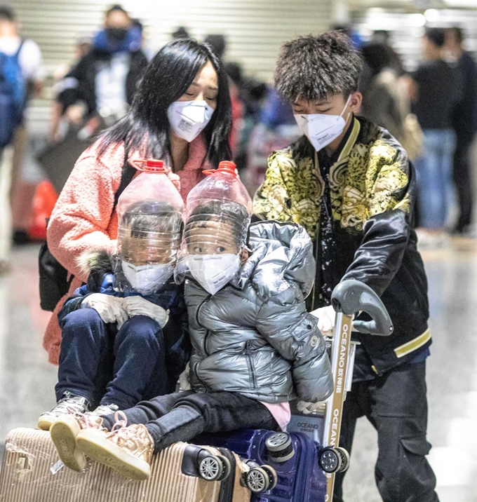 한 중국인 가족이 1일 중국 광둥성 광저우국제공항에 도착한 뒤 신종 코로나바이러스에 대비하기 위해 생수병으로 급조한 마스크를 아이들에게 씌운 채 이동하고 있다. 광저우=EPA 연합뉴스