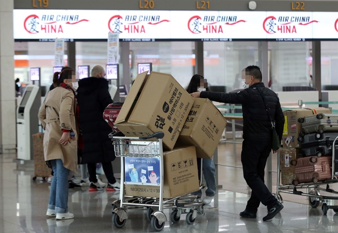 3일 오후 인천국제공항 1터미널에서 중국인 여행객들이 마스크 박스가 실린 카트를 밀고 탑승수속대로 향하고 있다. 연합뉴스