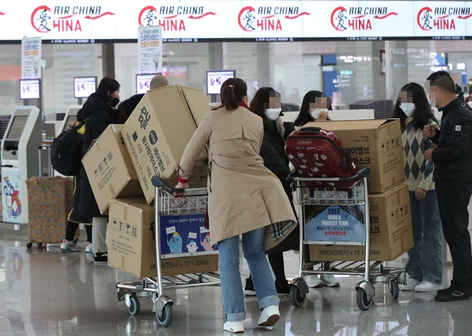 3일 오후 인천국제공항 1터미널에서 중국인 여행객들이 마스크 박스가 실린 카트를 밀고 탑승수속대로 향하고 있다. 연합뉴스