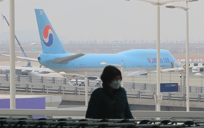 신종 코로나바이러스 감염증(우한폐렴)의 확산이 이어지는 가운데 2일 인천국제공항 제2여객터미널 계류장에 주기된 항공기 앞으로 마스크를 쓴 한 여행객이 이동하고 있다. 뉴스1