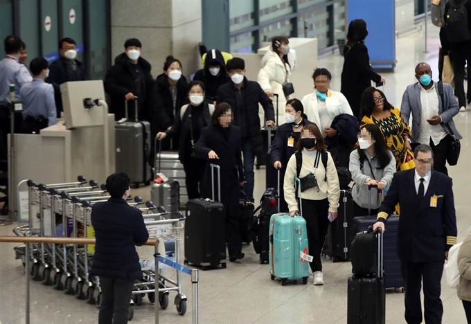 3일 오후 인천국제공항 제1여객터미널에서 승객들이 마스크를 쓴 채 입국하고 있다. 연합뉴스