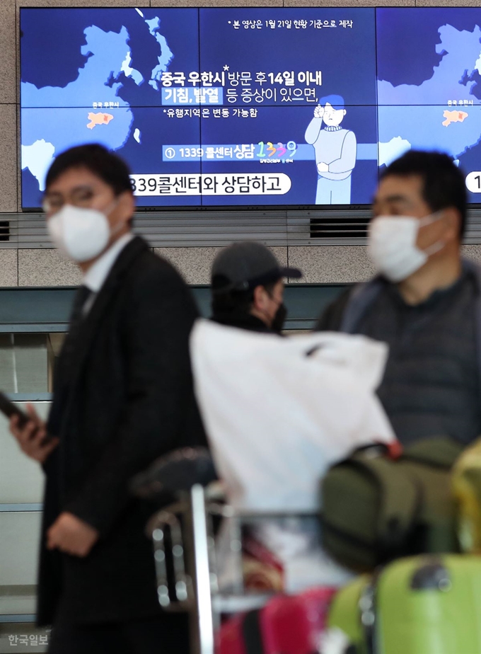 인천국제공항 방문객들이 4일 마스크를 한 채 공항 내 신종 코로나바이러스 감염증 안내문구 아래를 지나고 있다. 서재훈 기자 spring@hankookilbo.com