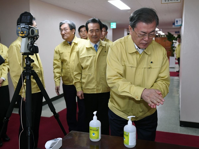 문 대통령이 30일 정부서울청사에서 열린 신종 코로나바이러스 감염증 대응 종합 점검회의에 앞서 손소독제로 소독을 하고 있다. 왕태석 선임기자