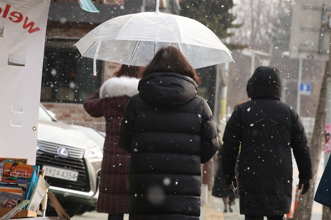 절기상 입춘인 4일 오후 서울 용산구 일대에서 시민들이 내리는 눈을 맞으며 발걸음을 재촉하고 있다. 연합뉴스