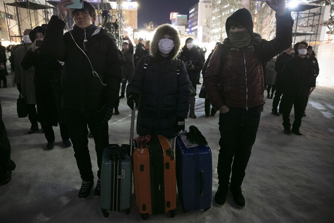 중국 우한에서 시작된 신종 코로나바이러스 감염증이 확산되는 가운데 4일 일본 홋카이도 삿포로에서 관광객들이 마스크를 착용하고 있다. 삿포로=AP 연합뉴스